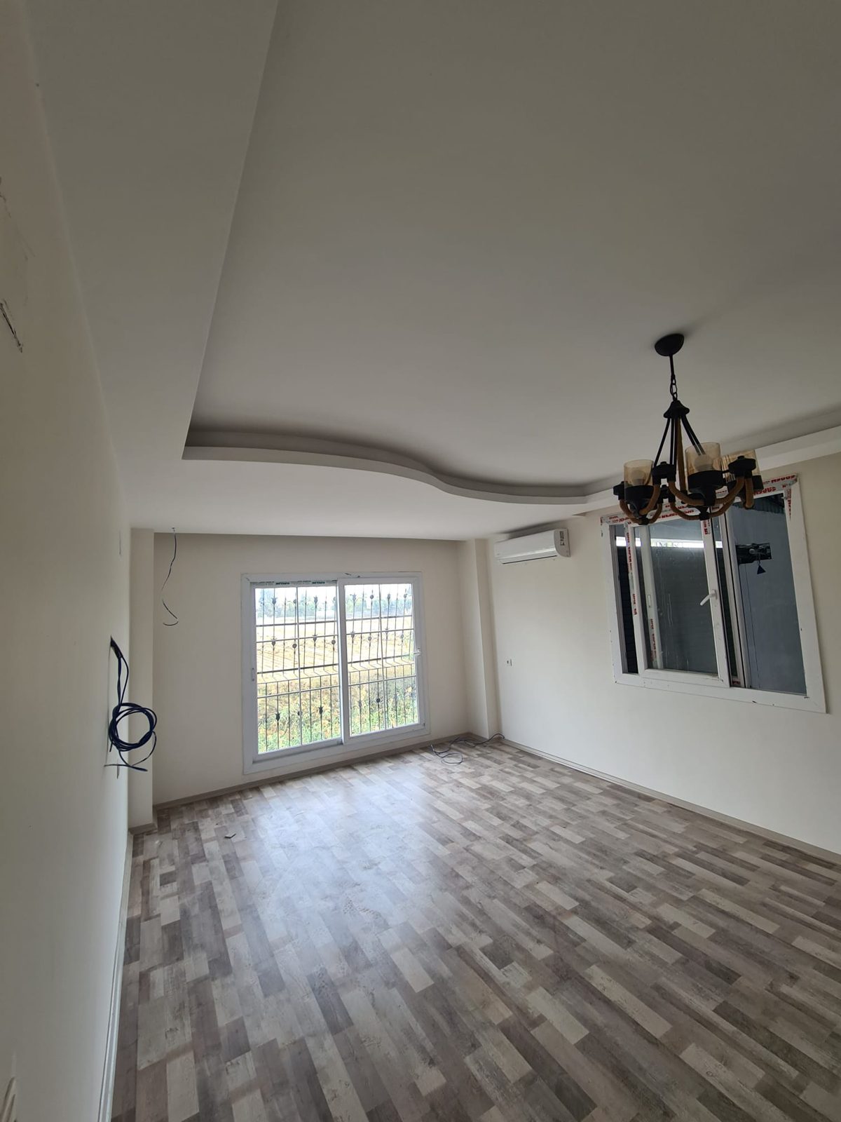 Finished living room with chandelier and new flooring, Calgary
